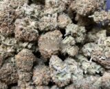 Close-up of Pinkman Goo cannabis buds with purple hues, orange hairs, and glistening trichomes